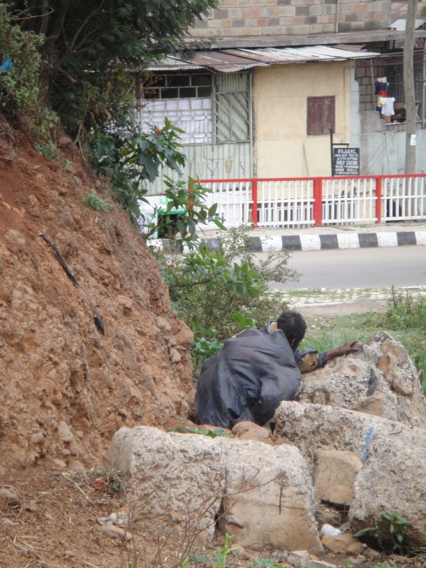 Man shitting in the street in Addis Ababa