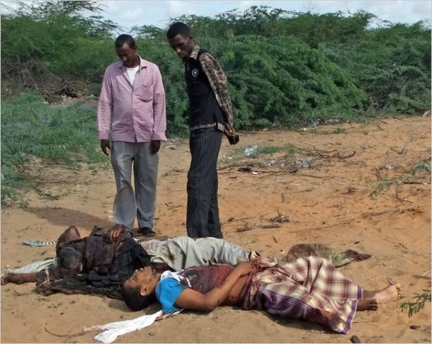 Men looked at the body of Fazul Abdullah Mohammed, front right, and another unidentified man in Mogadishu, Somalia, on Wednesday.