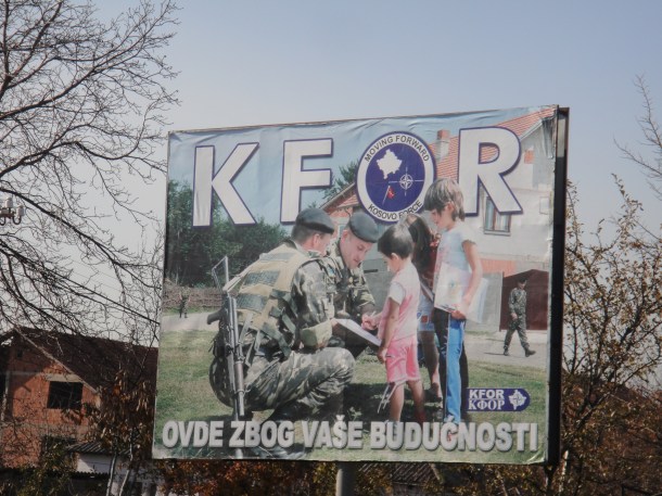 Signs promoting the positive impact of international troops in an effort to reduce tensions inside Kosovo